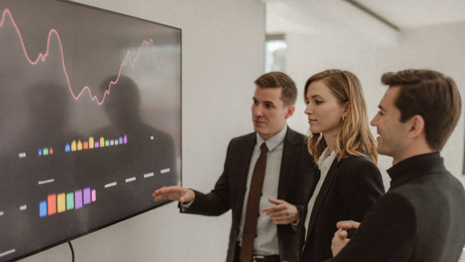 Team discussing metrics on a large dashboard display
